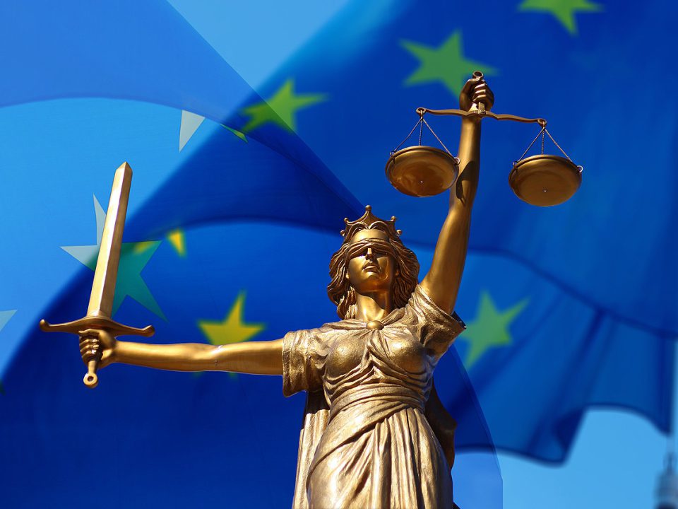 Statue der Justitia, im Hintergrund die Europafahne